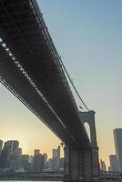 brooklyn bridge gegen die skyline von new york bei sonnenuntergang foto