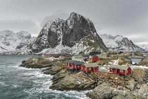 Fischerhütte in den Berggipfeln Hamnoy und Lilandstinden im Winter in Reine, Lofoten-Inseln, Norwegen. foto