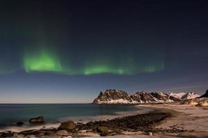 Nordlichter über dem Meer am Strand von Utakleiv, Lofoten, Norwegen im Winter. foto