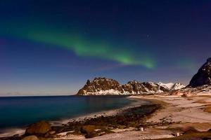 Nordlichter über dem Meer am Strand von Utakleiv, Lofoten, Norwegen im Winter. foto