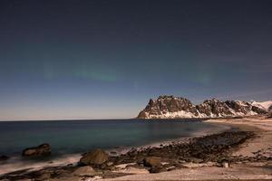 Nordlichter über dem Meer am Strand von Utakleiv, Lofoten, Norwegen im Winter. foto