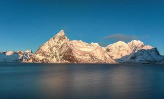 Fischerhütte in den Berggipfeln Hamnoy und Lilandstinden im Winter in Reine, Lofoten-Inseln, Norwegen. foto