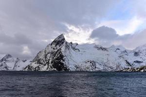 Fischerhütte in den Berggipfeln Hamnoy und Lilandstinden im Winter in Reine, Lofoten-Inseln, Norwegen. foto