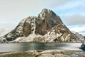 Fischerhütte in den Berggipfeln Hamnoy und Lilandstinden im Winter in Reine, Lofoten-Inseln, Norwegen. foto