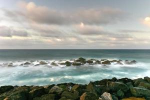 strand mit wellen, die gegen die felsen von san juan, puerto rico, kreuzen. foto