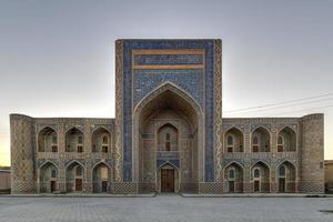 abdullah khan madrassah rühmt sich des perfekt dekorierten innenhofs mit den blau gekachelten maßwerken an den wänden in buchara, usbekistan. foto