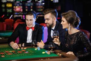 Schöne und reiche Leute, die im Casino Roulette spielen foto