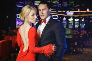 junges und schönes und gut gekleidetes Paar im Casino foto
