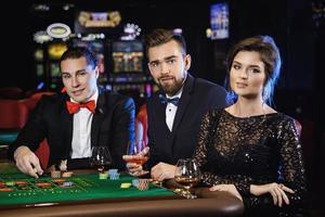 Schöne und reiche Leute, die im Casino Roulette spielen foto