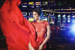 schöne Frau mit rotem Kleid im Casino foto