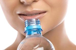 Mund und Flasche Wasser auf weißem Hintergrund foto