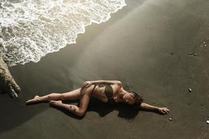 sexy Frau mit schönem Körper liegt am Strand foto