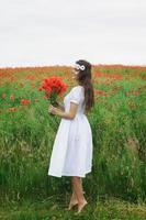 schöne Frau im Feld mit vielen Mohnblumen foto