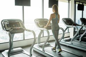 Junge und sportliche Frau auf dem Laufband im Fitnessstudio foto