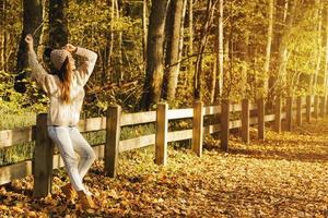 Junge und glückliche Frau im Park am sonnigen Herbsttag foto