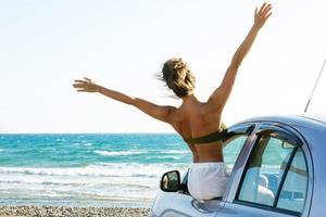 glückliche Frau und Auto am Strand foto