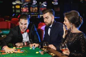 Schöne und reiche Leute, die im Casino Roulette spielen foto