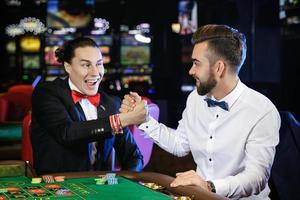 hübsche Jungs, die im Casino Roulette spielen foto