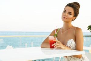 Frau im schönen Kleid mit Glas Cocktail foto