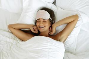 glückliche Frau, die nach gutem Schlaf aufwacht foto