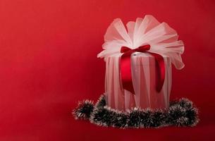 eingewickeltes Weihnachtsgeschenk auf rotem Hintergrund foto