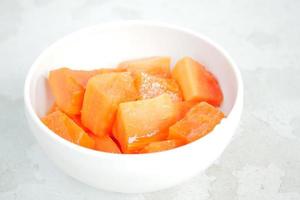 Stück Papaya auf weißem Teller, foto