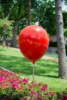 roter Ballon und Blumen in einem Park