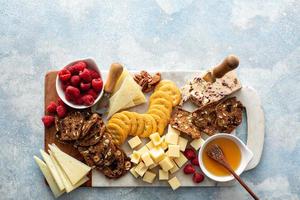 Käse- und Snackbrett mit Himbeere und Crackern foto