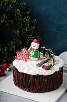schokoladenweihnachtsfestkuchen mit feiertagsdekorationen foto