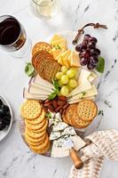 Käseplatte mit Crackern, Nüssen und Weintrauben foto