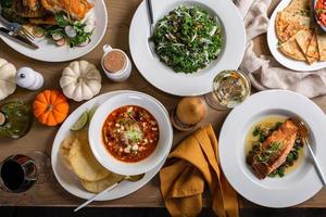 Herbst-Dinner-Overhead-Schuss mit Salat und Vorspeisen foto