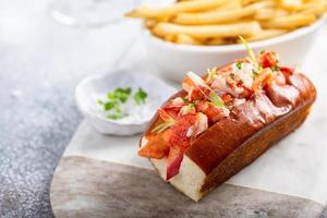 Hummerbrötchen mit Pommes auf einer Marmorplatte foto