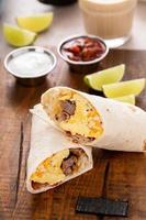 Frühstücks-Burrito mit Wurst, Eiern, Rösti und Käse foto