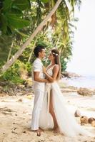 junges und schönes Paar feiert Hochzeit am Strand foto