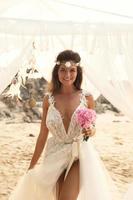 junge schöne braut, die hochzeit am strand feiert foto