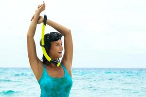 glückliche Frau am Strand mit Maske zum Schnorcheln foto