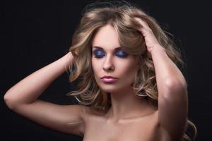 blonde Frau mit welligem Haar und buntem Make-up foto