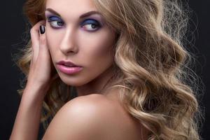 blonde Frau mit welligem Haar und buntem Make-up foto