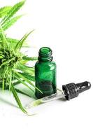 Cannabispflanze und Flasche mit einem cbd-Öl foto