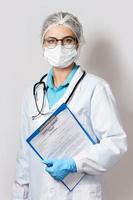 Ärztin, die einen Ordner mit einem Coronavirus-Testformular hält foto