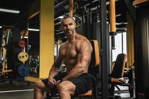 Schöner und muskulöser Bodybuilder in einem Fitnessstudio während des Trainings foto