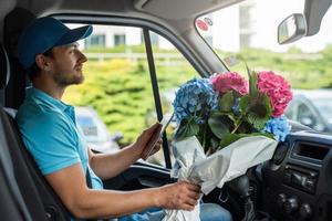 kurier im weißen van während der blumenlieferung foto