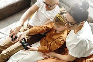 Die glückliche Familie spielt zu Hause eine Videospielkonsole foto