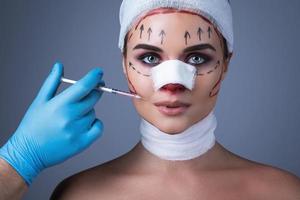 Eine mit Verbänden und Narben umwickelte Frau wird für eine weitere Operation vorbereitet. foto