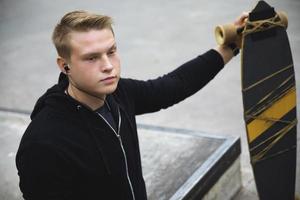 motivierter Behinderter mit Longboard im Skatepark foto