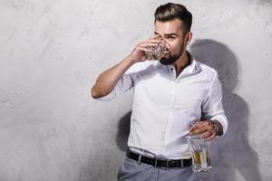 hübscher bärtiger mann mit einem glas whisky foto