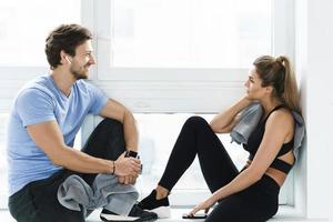 Mann und Frau ruhen sich nach dem Training im Fitnessstudio aus foto