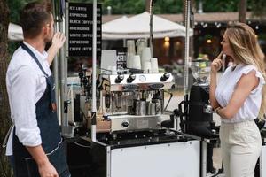 Barista-Mann bietet der Kundin verschiedene Kaffeesorten an foto