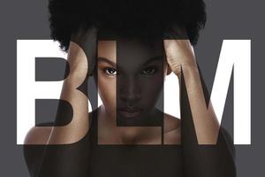Porträt einer jungen schwarzen Frau mit einem Schriftzug blm
