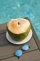frisches kokosgetränk und sonnenbrille auf dem tisch foto